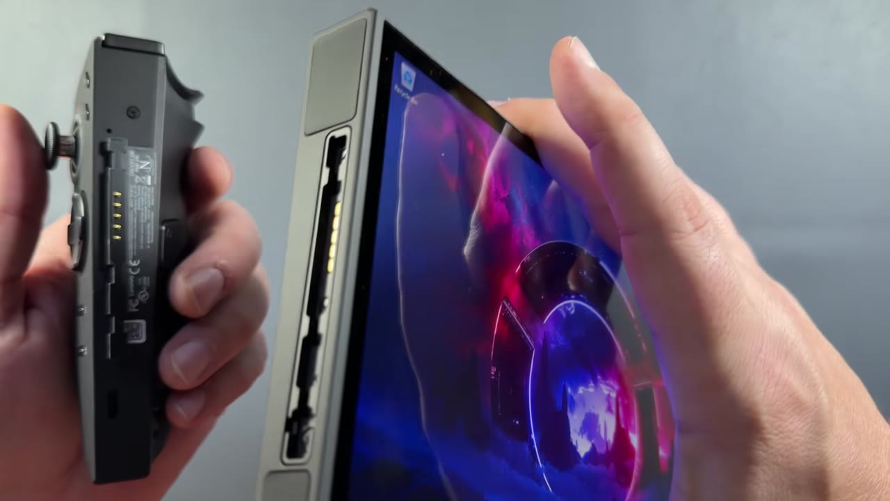 A detached Legion Go 2 controller next to the handheld's screen