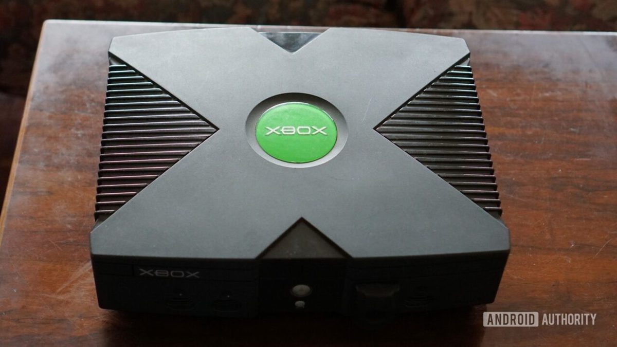 Original Microsoft Xbox console with the green Xbox logo, sitting on a wooden table